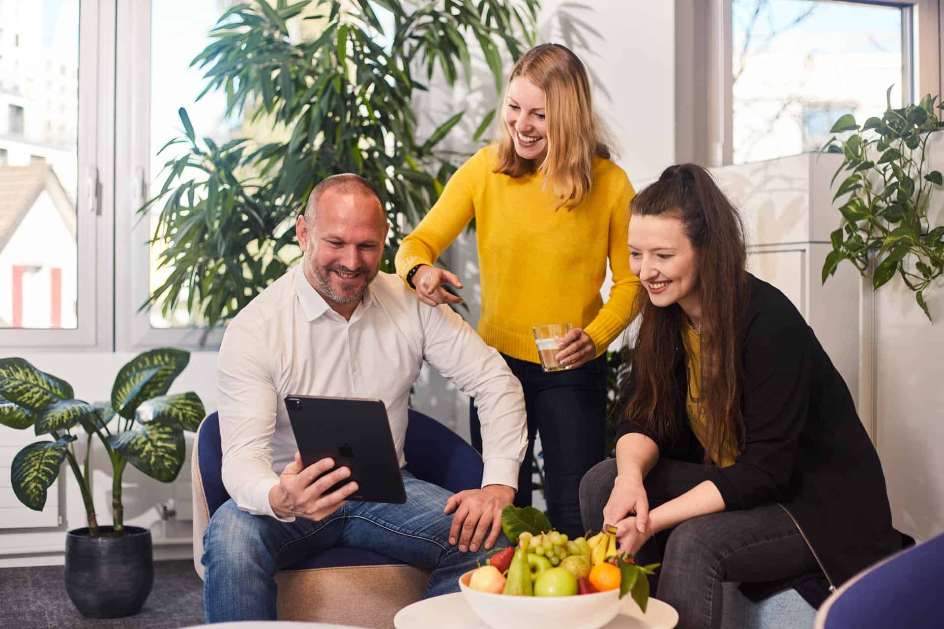 Gruppe von Menschen um ein Tablet Foto